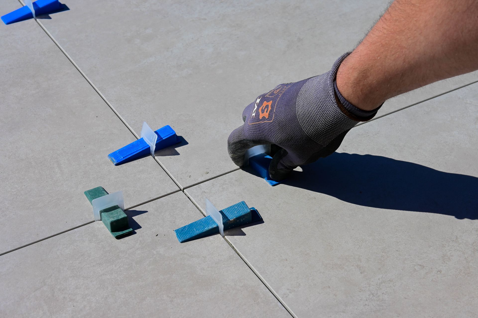 Professional tiler installing floor tiles with precision levelling spacers