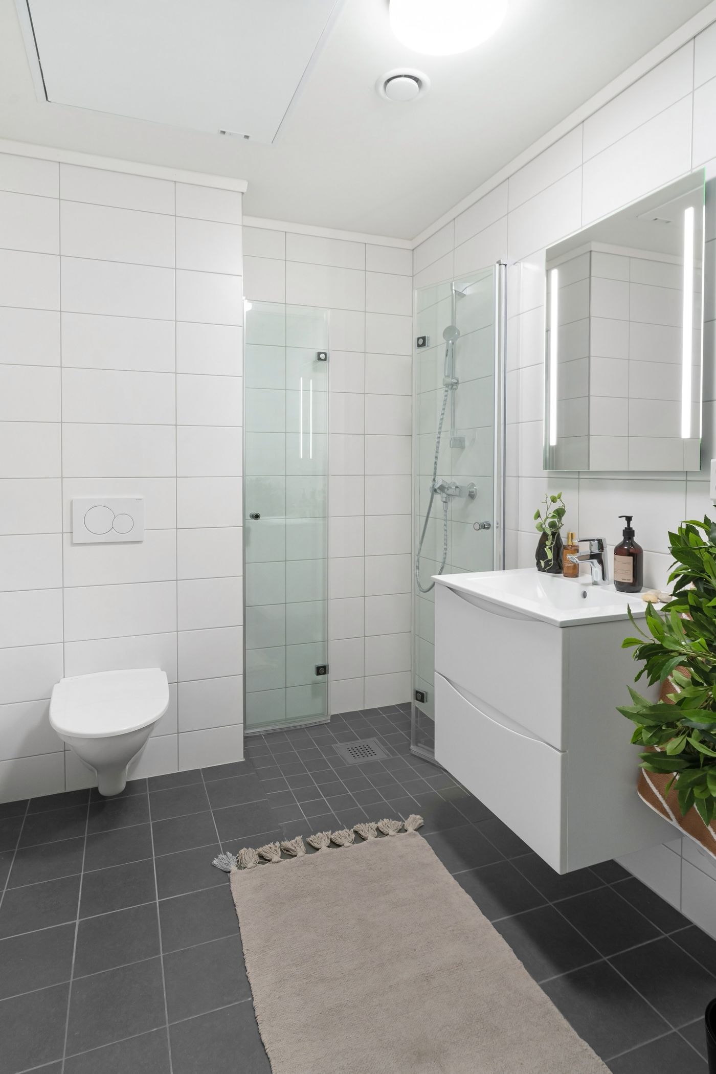 Bright renovated bathroom with tiled shower and floor
